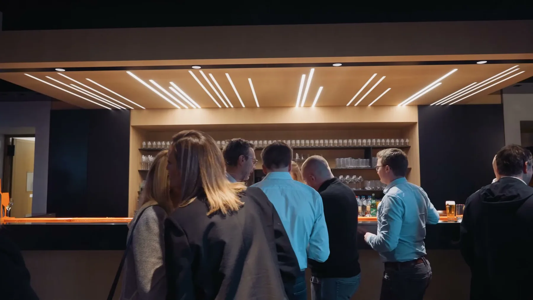 Le comptoir du bar en soirée, sous ses lignes de lumière