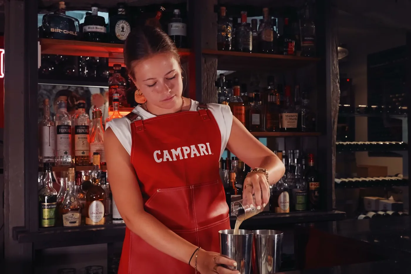 La barmaid au comptoir, devant les bouteilles