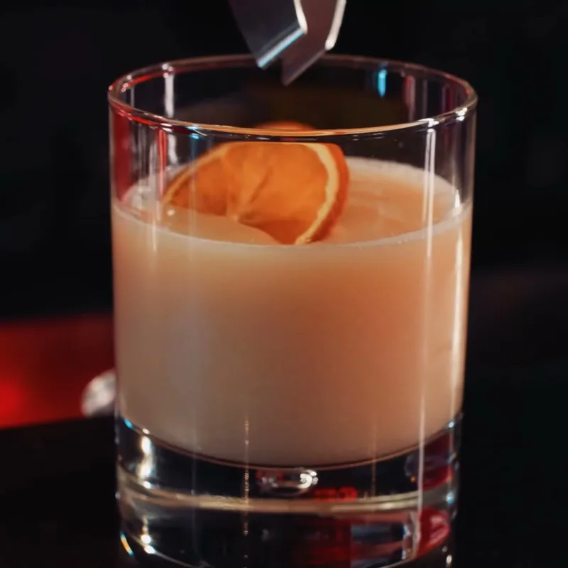 Un cocktail au comptoir du bar, tranche d'orange séchée