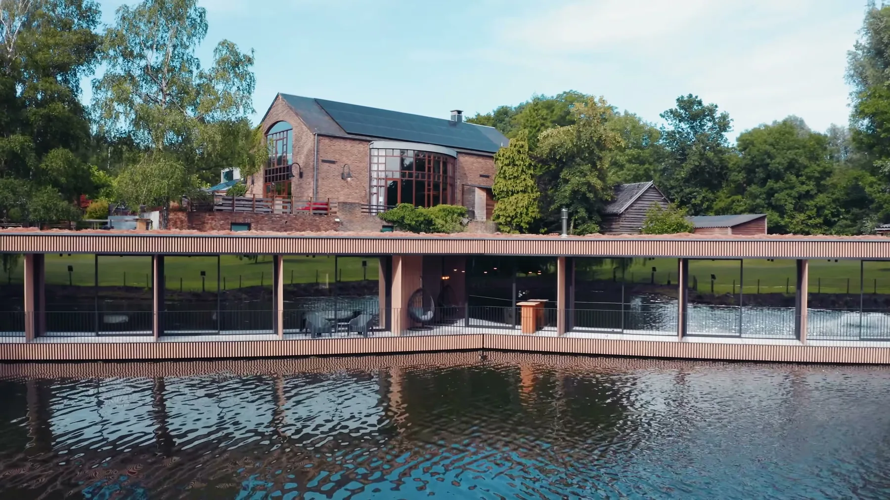 Le bâtiment de l'hôtel posé au bord de l'étang, et son reflet dans l'eau